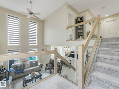 This interior view highlights a living area with high ceilings, large windows featuring blinds, and a ceiling fan - 1147 Lincoln Crescent, Edmonton, AB - Indoor Photo Showing Other Room
