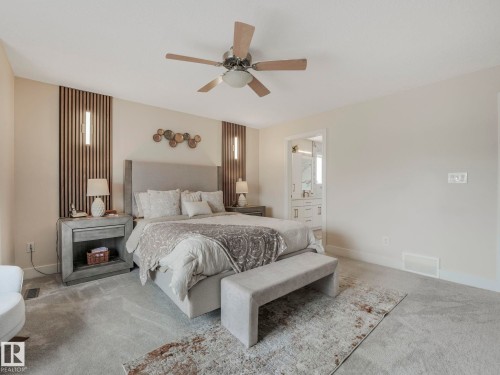 The bedroom features neutral-toned walls, light-colored carpeting, a ceiling fan, and access to a bathroom - 1147 Lincoln Crescent, Edmonton, AB - Indoor Photo Showing Bedroom