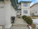 The property features a stucco exterior, a prominent front entrance with a double door, and a concrete pathway leading to the entrance - 1147 Lincoln Crescent, Edmonton, AB  - Outdoor With Facade 
