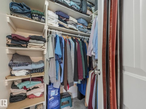 Thoughtfully organized closet space featuring built-in shelving, hanging rods, and a door-mounted belt rack - 1147 Lincoln Crescent, Edmonton, AB - Indoor With Storage