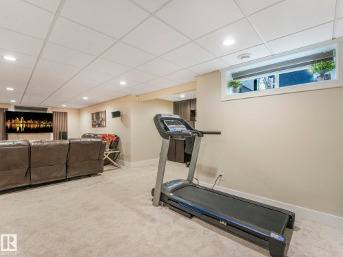 This versatile room features neutral-toned walls and carpet, recessed lighting, and a drop ceiling - 1147 Lincoln Crescent, Edmonton, AB - Indoor Photo Showing Gym Room
