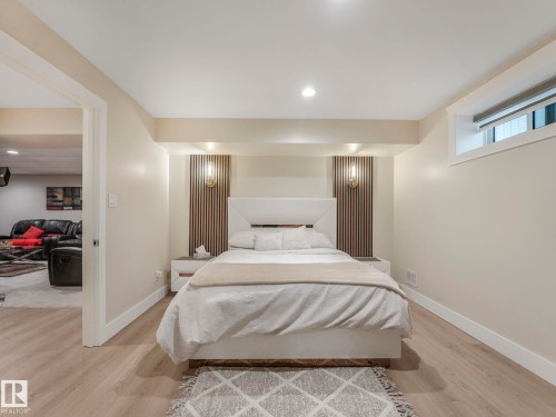 The bedroom features light-toned flooring, a window with a blind, and recessed lighting - 1147 Lincoln Crescent, Edmonton, AB - Indoor Photo Showing Bedroom