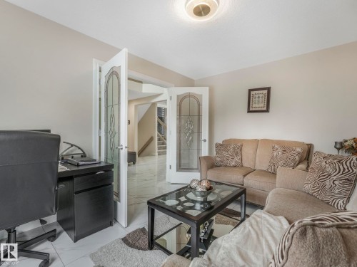 This space features light-colored walls and white tile flooring - 1147 Lincoln Crescent, Edmonton, AB - Indoor Photo Showing Living Room