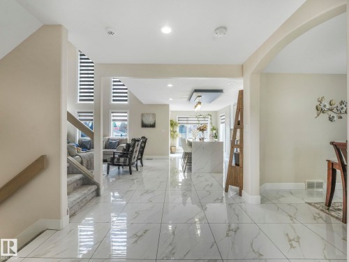 The property features a bright and spacious interior with polished tile flooring throughout the main living areas - 1147 Lincoln Crescent, Edmonton, AB - Indoor Photo Showing Other Room