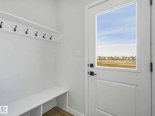 Entryway featuring a built-in bench, wall-mounted coat rack, and a door with a window - 275 Munn Way, Leduc, AB - Indoor Photo Showing Other Room