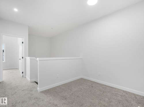 This interior space features light grey carpeting, white walls, and a white ceiling with a recessed light fixture - 275 Munn Way, Leduc, AB - Indoor Photo Showing Other Room