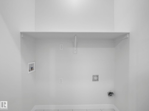 Dedicated utility space with a built-in shelf, electrical outlets, and plumbing connections - 275 Munn Way, Leduc, AB - Indoor With Storage