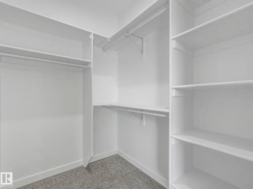 The property includes a walk-in closet with white shelving and hanging rods - 275 Munn Way, Leduc, AB - Indoor With Storage