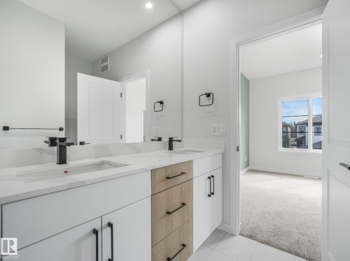 Bathroom with a double vanity featuring a white countertop, two rectangular sinks, and matte black faucets - 275 Munn Way, Leduc, AB - Indoor Photo Showing Bathroom