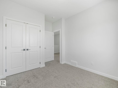 This room features white walls, light grey carpet, and white trim - 275 Munn Way, Leduc, AB - Indoor Photo Showing Other Room