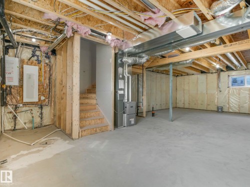 The unfinished basement features exposed wooden joists, concrete flooring, and a window providing natural light - 275 Munn Way, Leduc, AB - Indoor Photo Showing Basement
