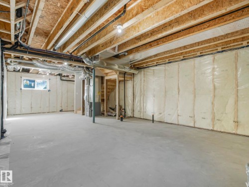 Spacious unfinished basement with exposed wooden beams, concrete flooring, and insulated walls - 275 Munn Way, Leduc, AB - Indoor Photo Showing Basement
