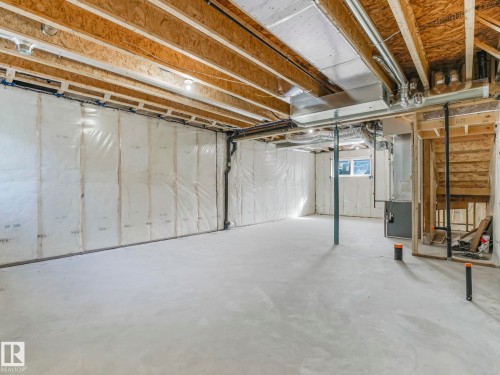 Expansive unfinished basement featuring concrete flooring, exposed ceiling joists, and a window - 275 Munn Way, Leduc, AB - Indoor Photo Showing Basement