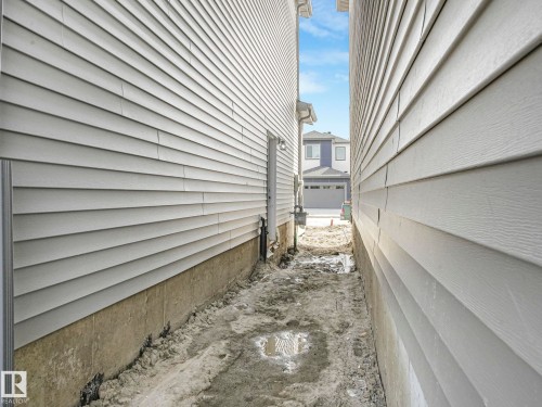 The property features light-colored horizontal siding and a visible foundation - 275 Munn Way, Leduc, AB - Outdoor