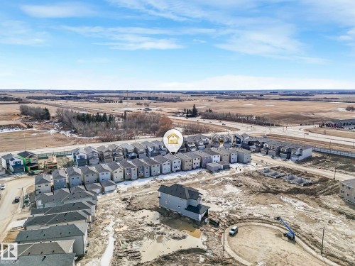 Aerial view of the property and its surrounding neighbourhood, featuring a road and open fields - 275 Munn Way, Leduc, AB - Outdoor With View