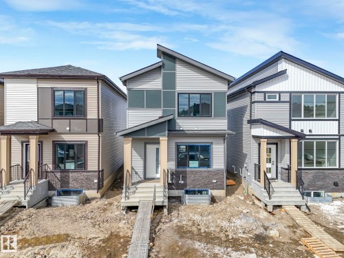The property features a modern exterior design with mixed siding in grey tones, an angular roofline, and a covered entry with columns - 275 Munn Way, Leduc, AB - Outdoor With Facade