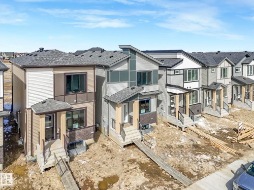 Modern residences featuring a combination of siding and brick facades, large windows, and covered entryways - 275 Munn Way, Leduc, AB - Outdoor With Facade