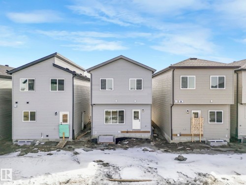 The property presents a two-story exterior with light gray siding and dark roofing - 275 Munn Way, Leduc, AB - Outdoor With Exterior