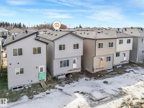 Property with light gray siding and a dark roof, featuring windows on both levels - 275 Munn Way, Leduc, AB - Outdoor With Exterior