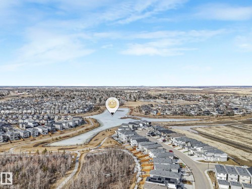 Aerial view of the surrounding neighbourhood, featuring numerous properties, a body of water, and natural areas - 275 Munn Way, Leduc, AB - Outdoor With View