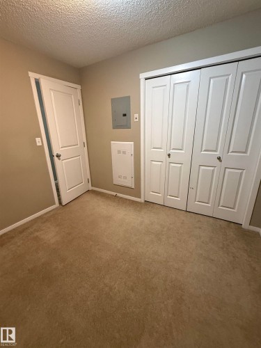 Room featuring carpeting, painted walls, and white bi-fold closet doors - 104 3207 James Mowatt Trail, Edmonton, AB - Indoor Photo Showing Other Room