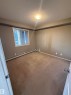 This room features wall-to-wall carpeting, a window with blinds, and baseboard heating - 104 3207 James Mowatt Trail, Edmonton, AB  - Indoor Photo Showing Other Room 
