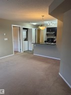 This property features a kitchen with dark cabinetry, integrated stove, and a double basin sink - 