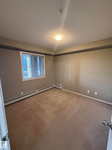 Room with carpeted flooring, a window with blinds, and a ceiling-mounted light fixture - 104 3207 James Mowatt Trail, Edmonton, AB - Indoor Photo Showing Other Room