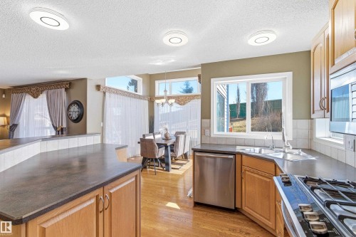 Open-concept kitchen and dining area featuring hardwood floors, ample natural light from several windows, and recessed lighting - 442 Hunters Green, Edmonton, AB - Indoor Photo Showing Kitchen With Double Sink