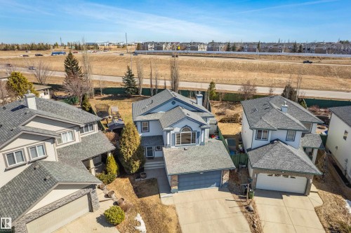 Aerial view of the property, showcasing its light-colored exterior, an attached garage, and a driveway - 442 Hunters Green, Edmonton, AB - Outdoor