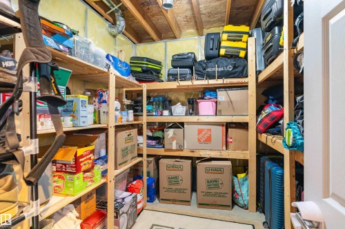 The property features an extensive storage area with comprehensive wooden shelving units, offering significant organizational space - 442 Hunters Green, Edmonton, AB - Indoor Photo Showing Other Room