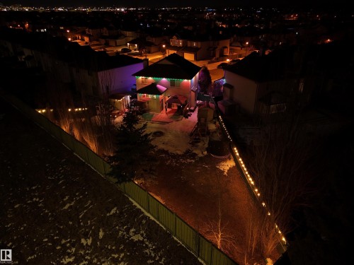 The property features an illuminated exterior and a yard with trees - 442 Hunters Green, Edmonton, AB - Outdoor