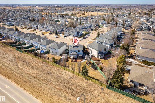 Aerial view of the property and surrounding neighborhood, featuring residential homes with grey roofs and a clear blue sky - 442 Hunters Green, Edmonton, AB - Outdoor With View