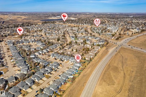 Aerial view of the neighborhood showcasing residential properties, paved roads, and surrounding undeveloped land - 442 Hunters Green, Edmonton, AB - Outdoor With View