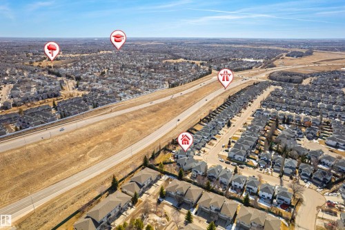 Aerial view of the surrounding residential areas, featuring houses with grey roofs and a clear road network - 442 Hunters Green, Edmonton, AB - Outdoor With View