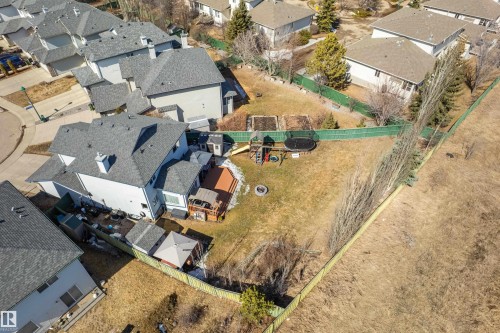 Expansive property featuring a large backyard with a wooden deck, a sizable lawn, and mature trees along the perimeter - 442 Hunters Green, Edmonton, AB - Outdoor With View