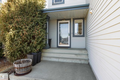 The property features a concrete front entrance with steps, a storm door, and horizontal siding - 442 Hunters Green, Edmonton, AB - Outdoor With Exterior