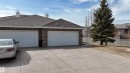 The property features a brick exterior, a shingled roof, and an attached double garage with white doors - 6604 Sandin Cove, Edmonton, AB  - Outdoor With Exterior 