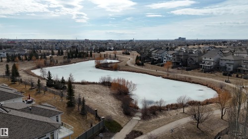 The property offers views of a scenic pond and surrounding landscape, with residential homes visible in the background - 6604 Sandin Cove, Edmonton, AB - Outdoor With View