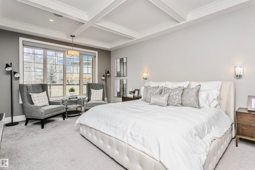 This bedroom features a coffered ceiling, large windows providing natural light, and light-colored carpeting - 3435 Keswick Boulevard, Edmonton, AB 