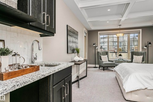 This space features a coffered ceiling, carpeted flooring, and a large window providing ample natural light - 3435 Keswick Boulevard, Edmonton, AB 