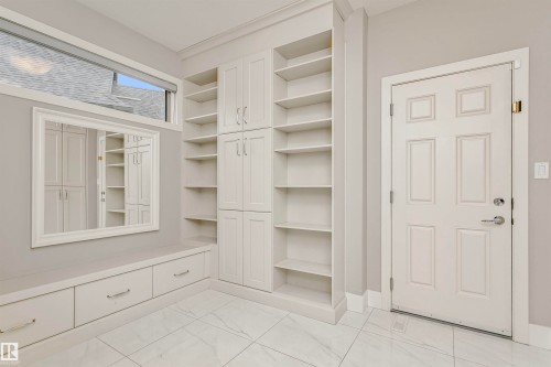 Entryway featuring white tile flooring, built-in shelving, and a window - 3435 Keswick Boulevard, Edmonton, AB 