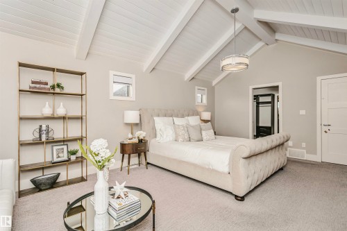 This room features a vaulted ceiling with exposed beams, light gray carpeting, and a modern drum pendant light fixture - 3435 Keswick Boulevard, Edmonton, AB 