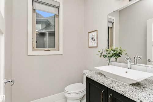 This bathroom features a contemporary vanity with a granite countertop and a vessel sink - 3435 Keswick Boulevard, Edmonton, AB 
