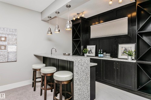 The property features a built-in bar area with a granite countertop and a sink - 3435 Keswick Boulevard, Edmonton, AB 