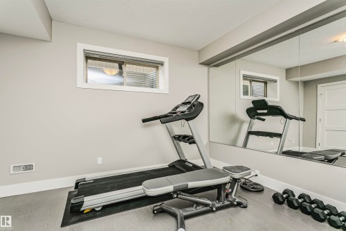 Dedicated fitness area featuring wall-mounted mirrors and a window - 3435 Keswick Boulevard, Edmonton, AB 