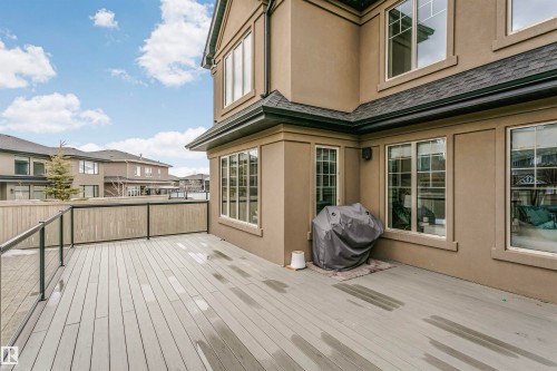 Spacious outdoor deck with a glass and wood panel railing, providing an extension of the living space - 3435 Keswick Boulevard, Edmonton, AB 