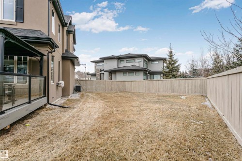 The property features a large yard with a wooden fence and a covered deck - 3435 Keswick Boulevard, Edmonton, AB 