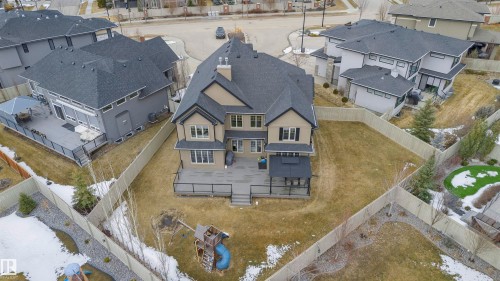 The property features a spacious backyard with a wooden deck, a covered patio area, and a fenced perimeter - 3435 Keswick Boulevard, Edmonton, AB 