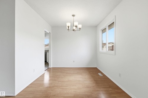 This room features light-toned flooring, white walls, and a multi-bulb ceiling fixture - 1707 65 Street, Edmonton, AB - Indoor Photo Showing Other Room